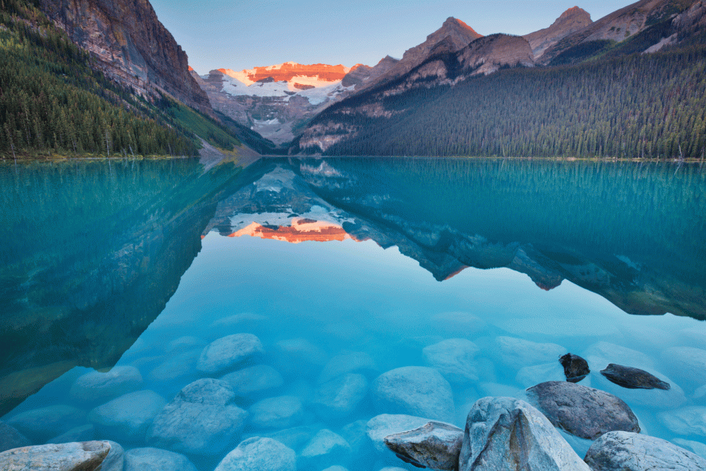 A lake with rocks and mountains in the background.