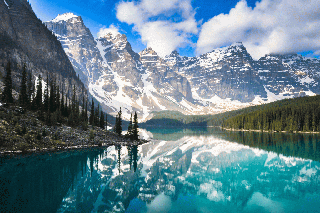 The mountains are reflected in the water of a lake.