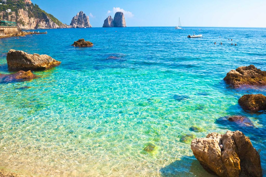 A picturesque beach with clear water and rocks in the background, perfect for celebrating Australia Day.