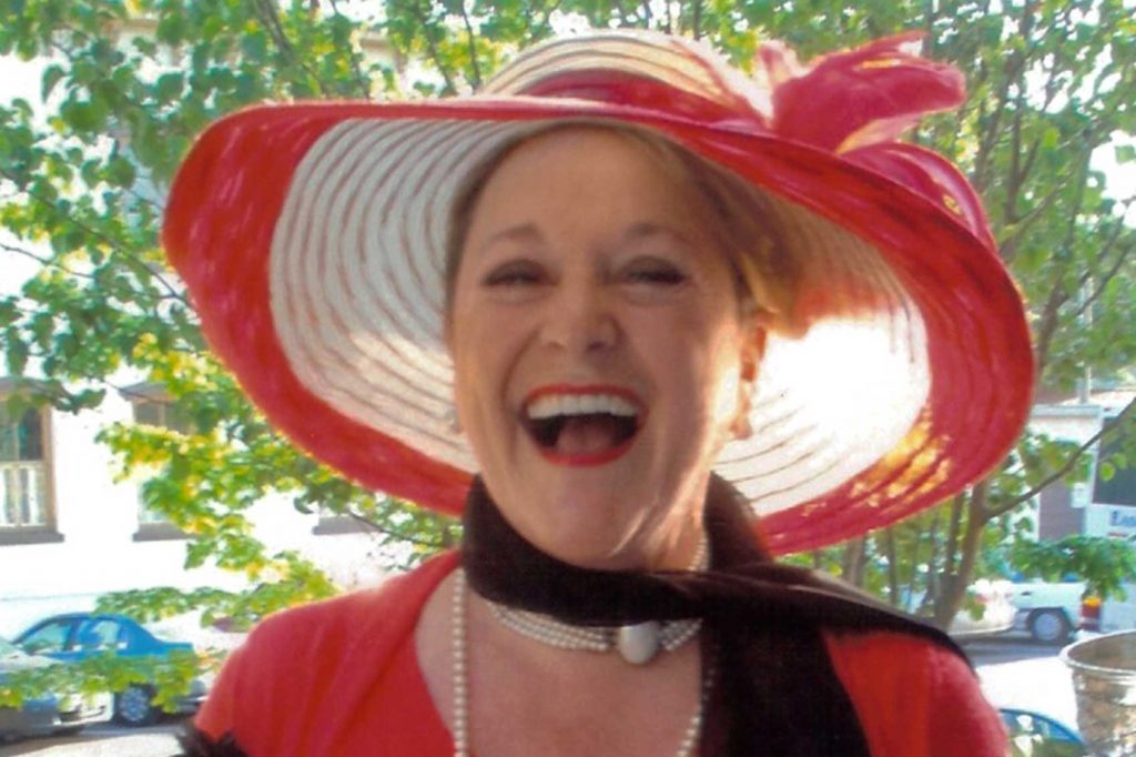 A woman wearing a red and white hat celebrates International Women's Day.