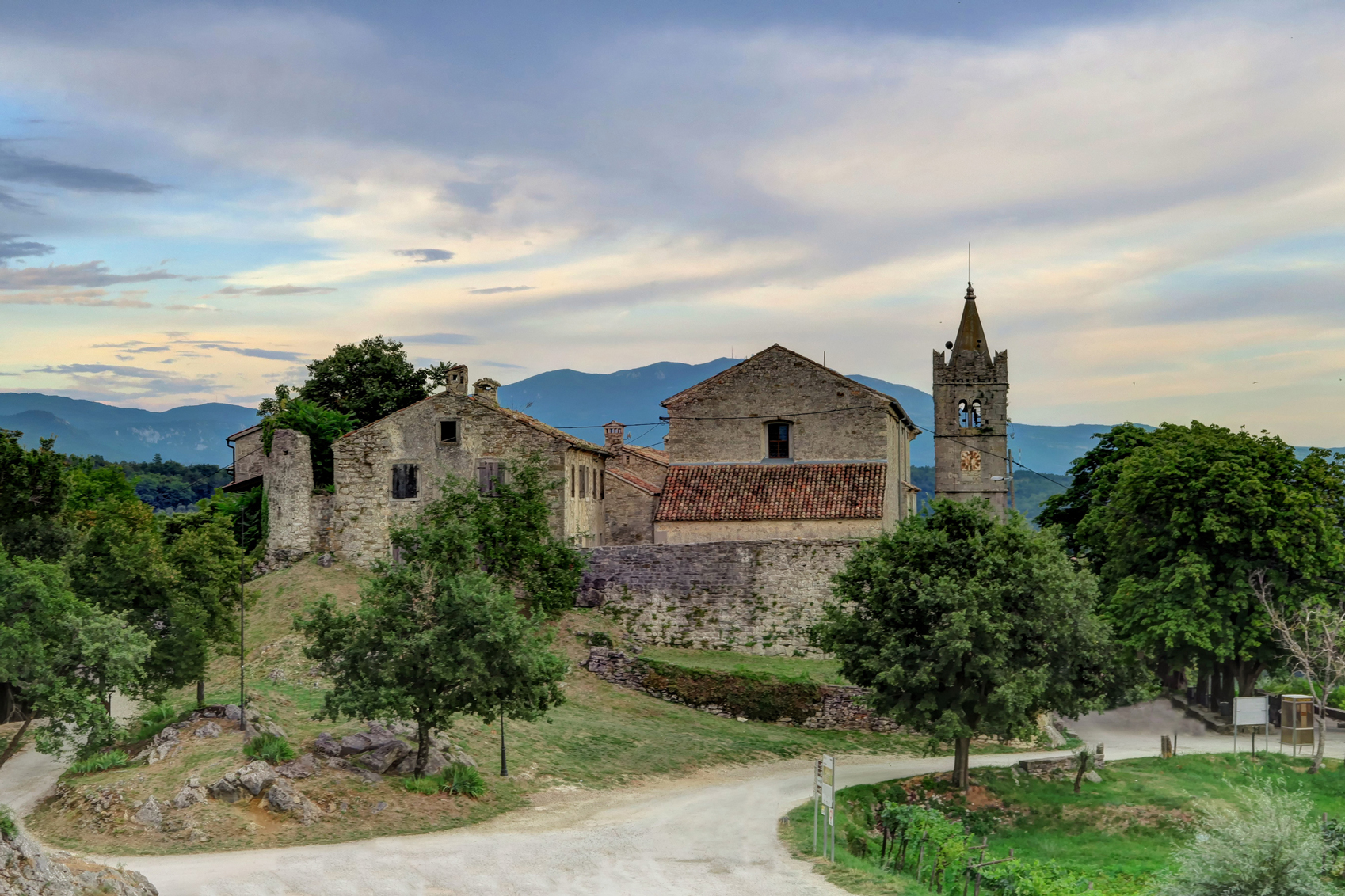 A church with a clock tower in the middle of a field, located in Croatia.