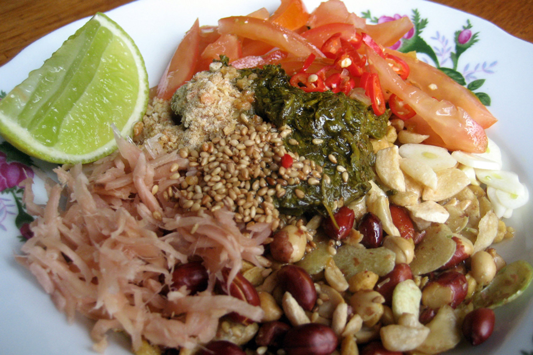 A white plate with a variety of Southeast Asian dishes on it.