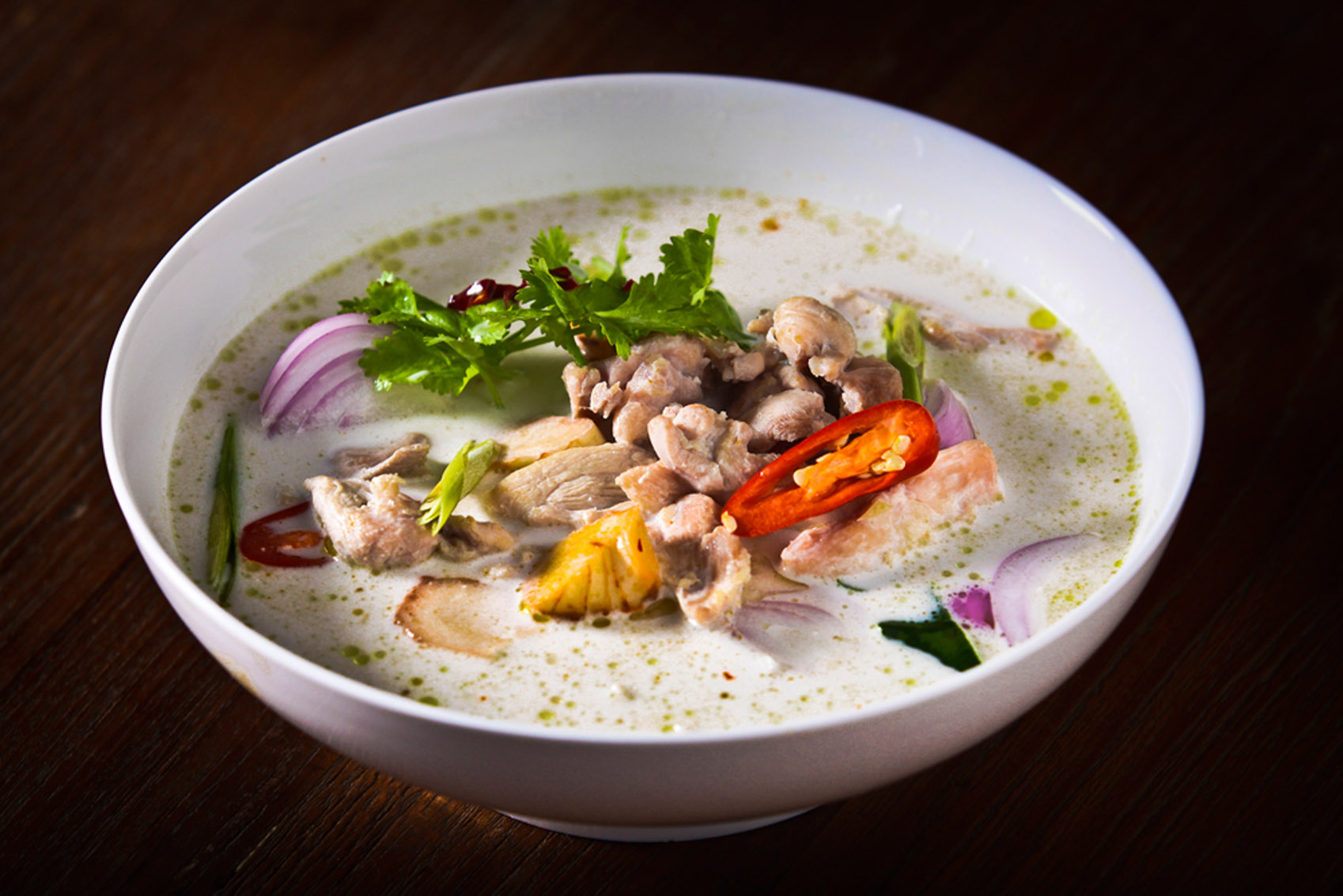 A Southeast Asian-inspired bowl of soup with meat and vegetables.