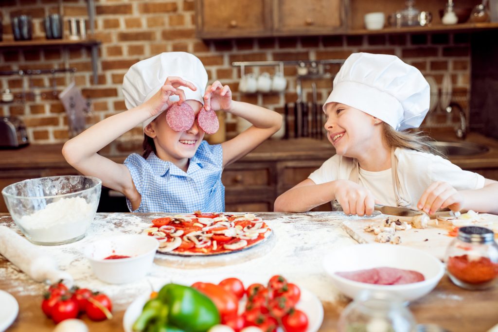 kid friendly trips kids in chef hats having fun while making pizza