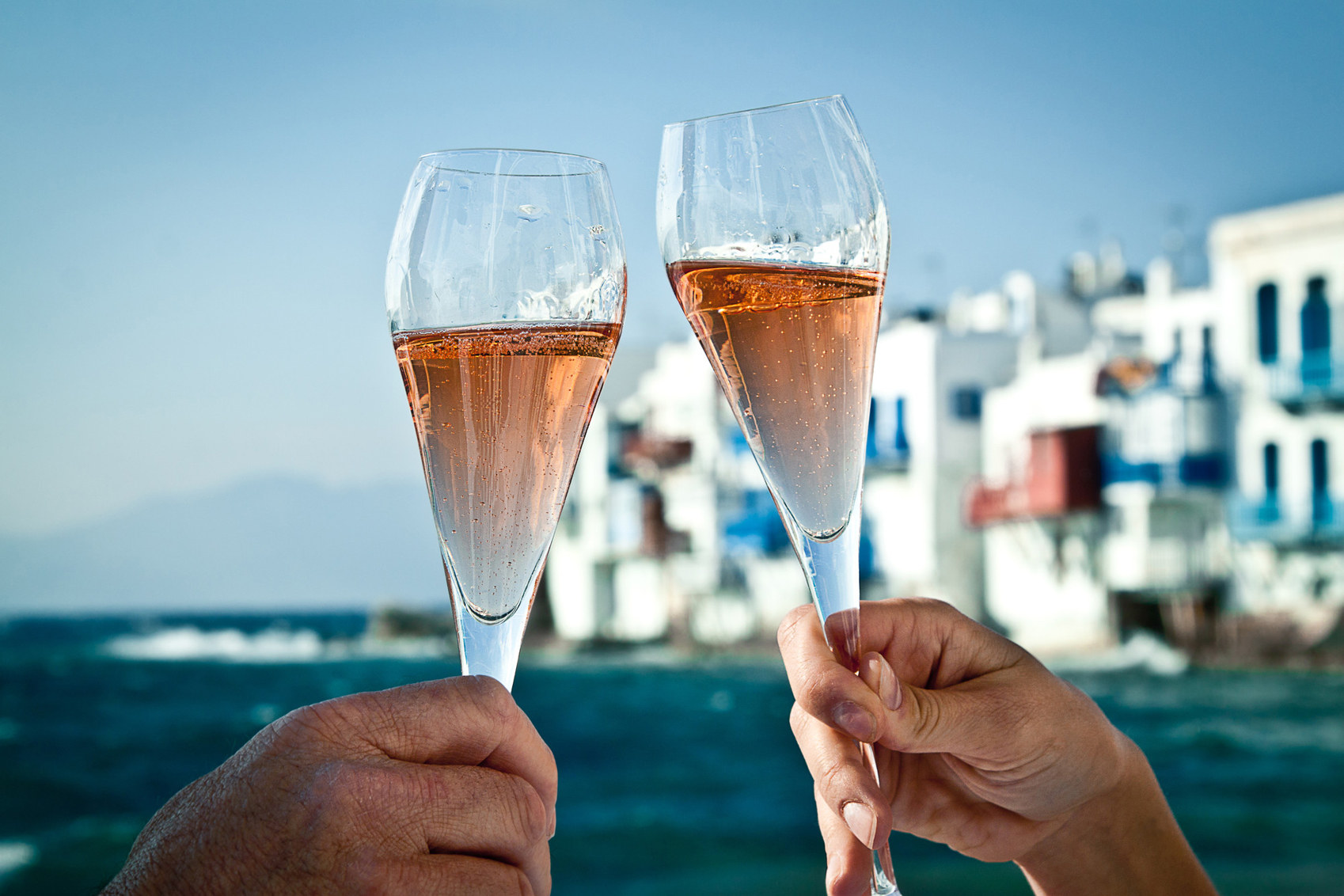 Revisit a Destination A romantic toast by the sea in Greece.
