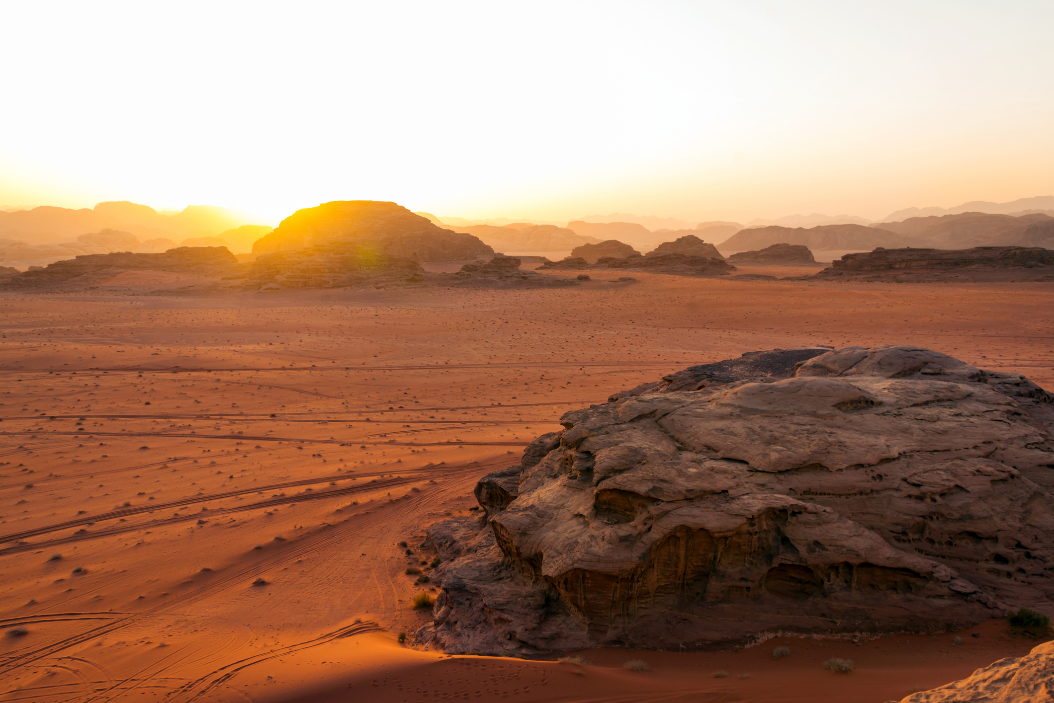The sun is setting over the sandy filming location.