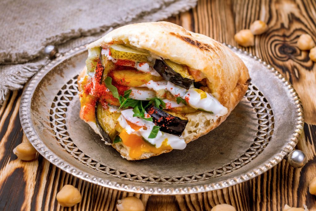 Indulge in a pita sandwich filled with vegetables and chickpeas, a must-try Middle Eastern delicacy.
