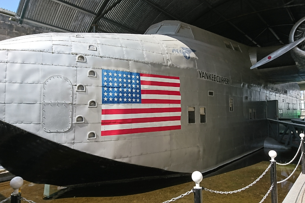 A large American flag is displayed on the side of a unique airplane.
