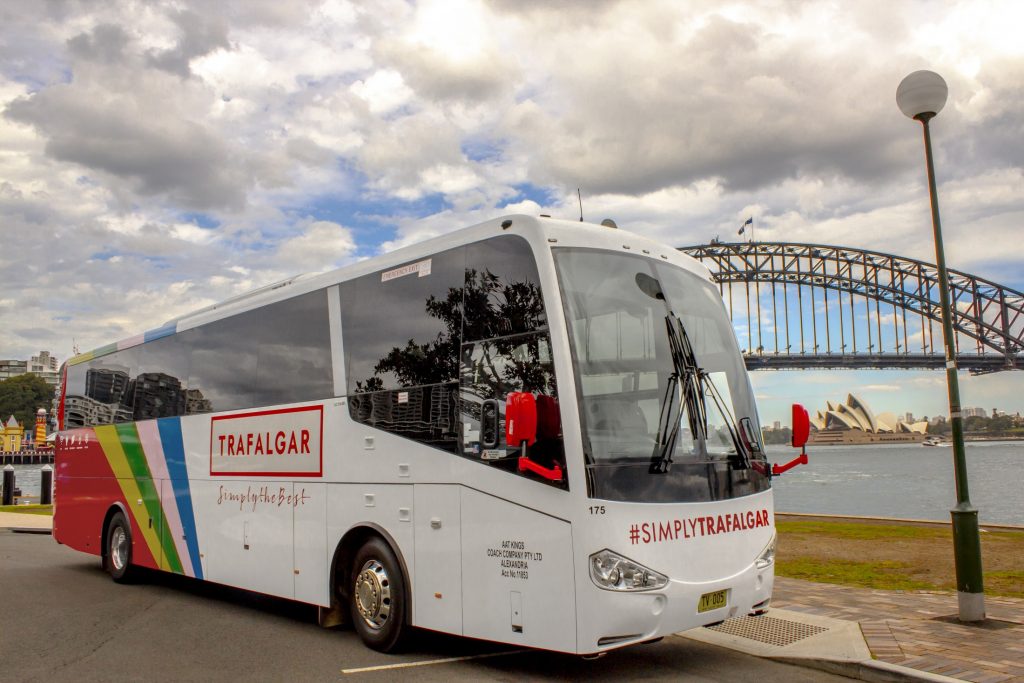 A bus parked on the side of a road near the sydney harbour bridge.