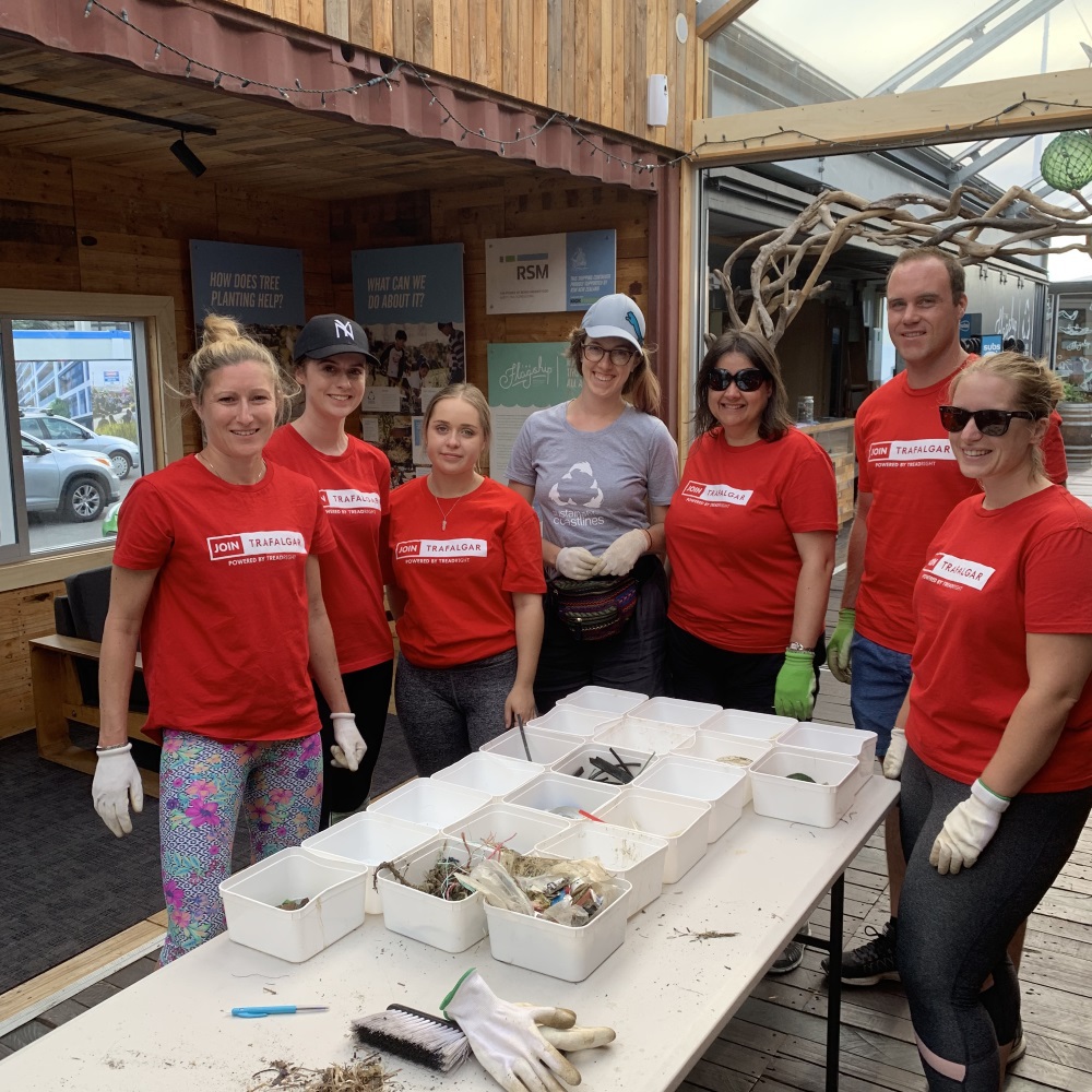 A group of people in red shirts posing in front of a table.
