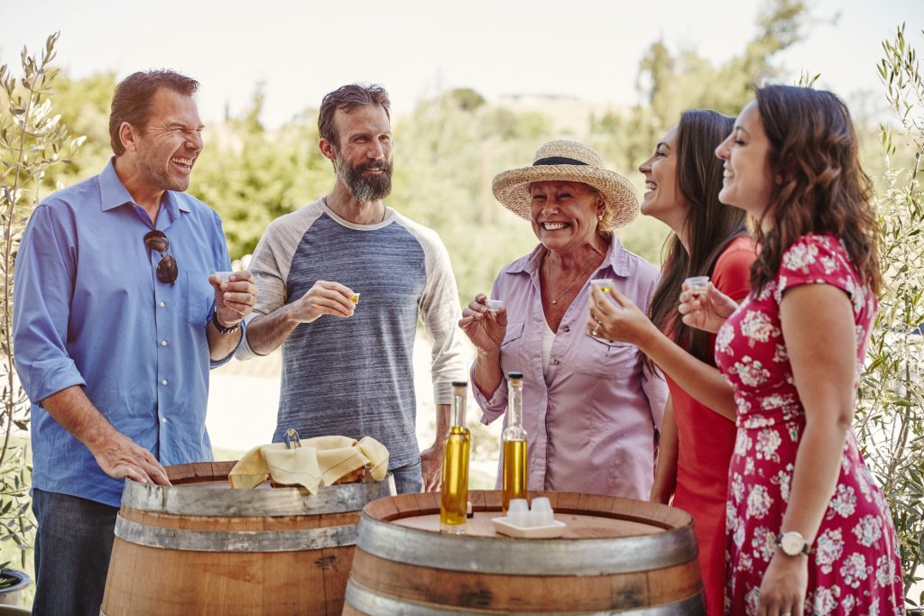A group of people standing around barrels of wine.