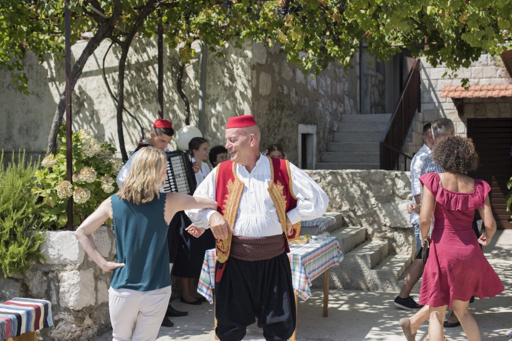 A group of Osojnik dancers are performing in a courtyard.