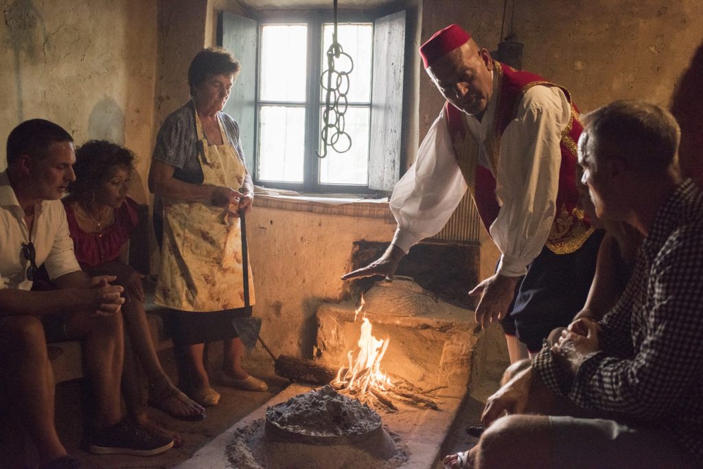A group of people sitting around a fire in an old house, enjoying the warmth and camaraderie.