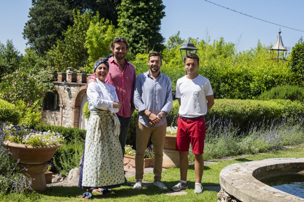 A group of people posing in front of a fountain in a garden.