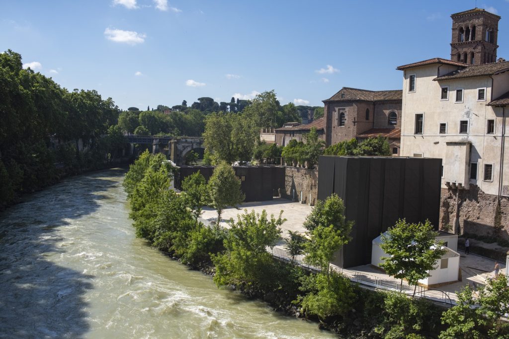 A river runs next to a building and trees.