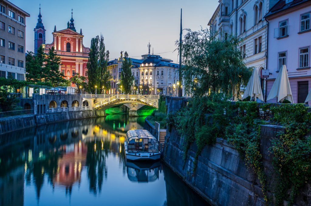 A canal in a city with buildings and a bridge.