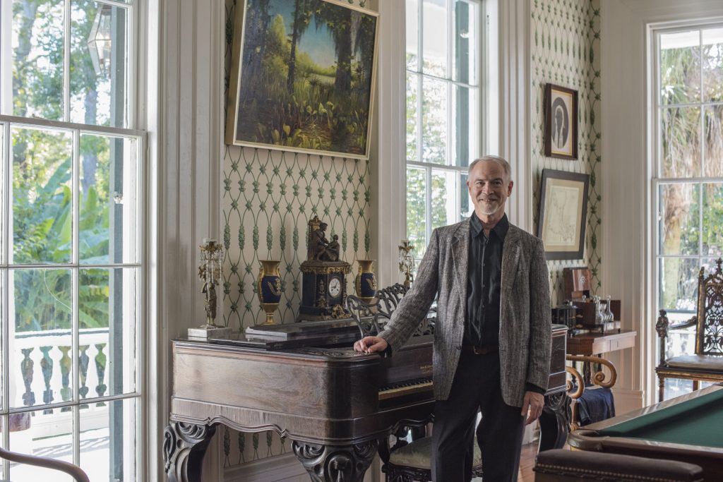 A man standing in front of a room with a pool table.