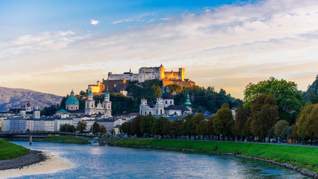 Salzburg castle on a hill overlooking a river in salzburg, austria.