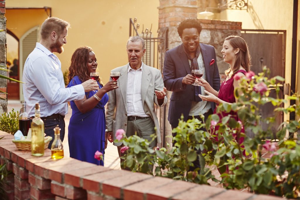 A group of people drinking wine in a garden.
