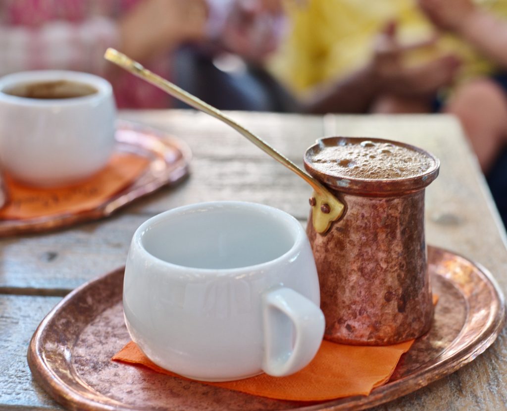 Two cups of coffee on a tray on a table, infused with Greek flavors.