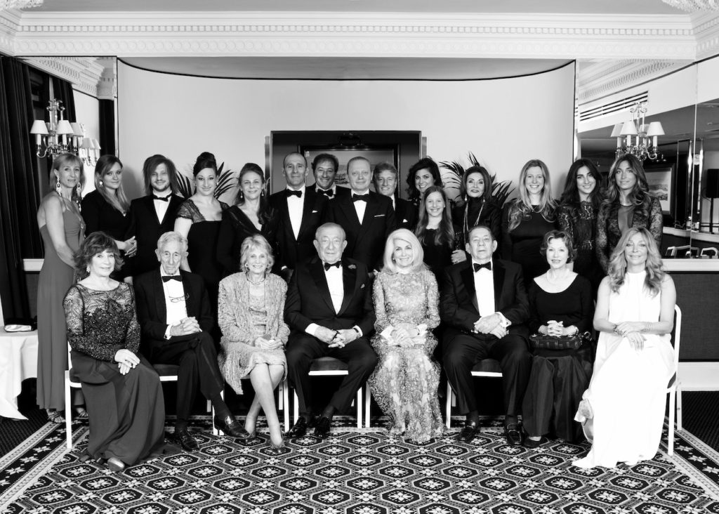 A black and white photo of a group of people in formal attire taken during a special event.