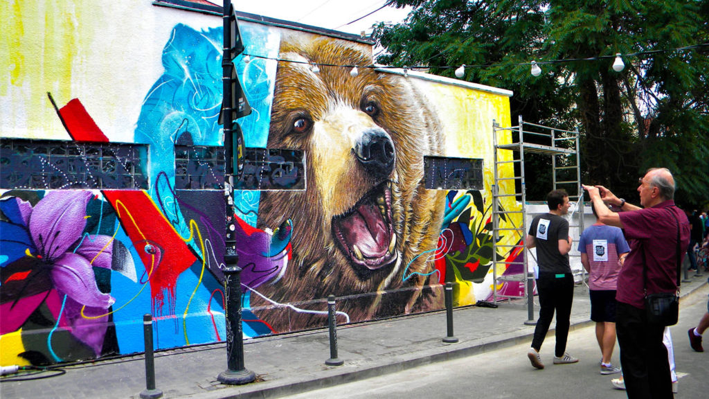 A colorful mural entitled "The Bear Express" featuring a brown bear near Bucharest's Carol I Park.