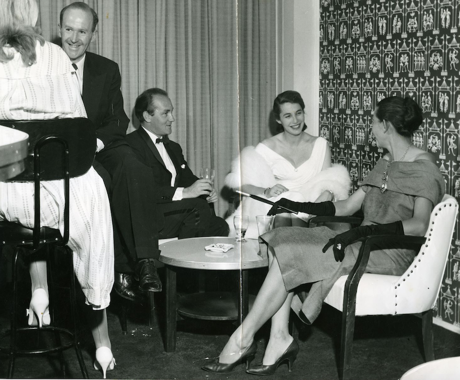 In honor of International Women's Day, a group of people in formal attire gather around a table.