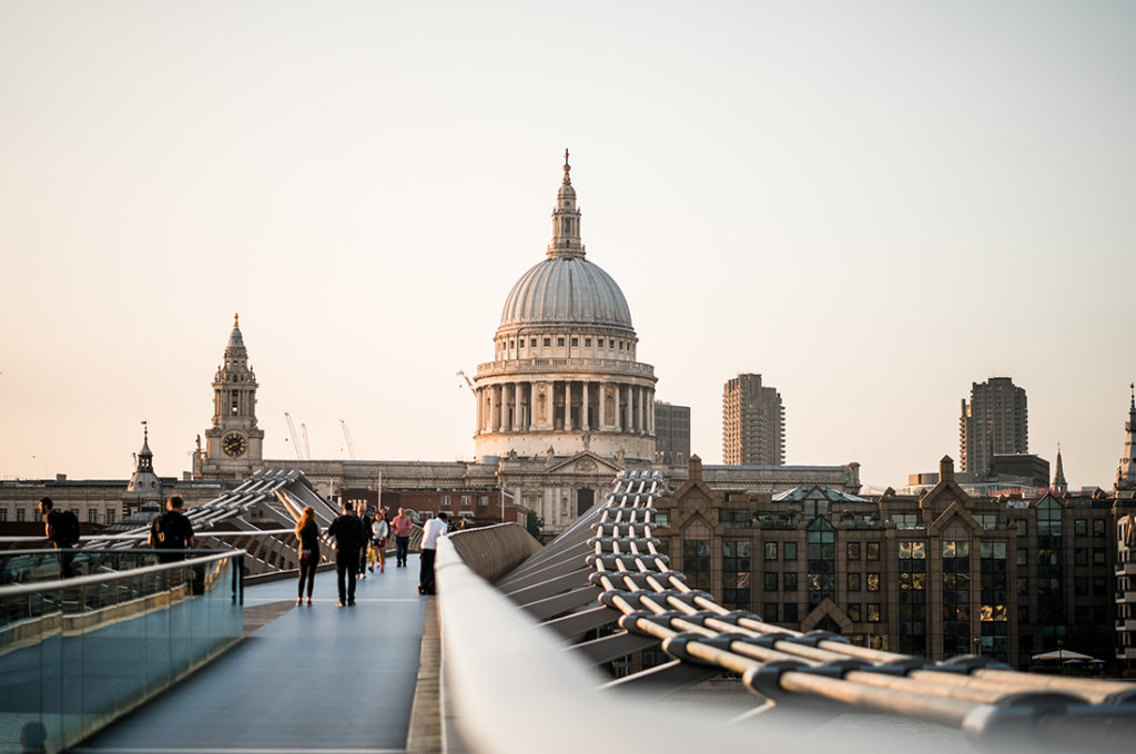 People strolling on a bridge in London, near the legacy of Winston Churchill.
