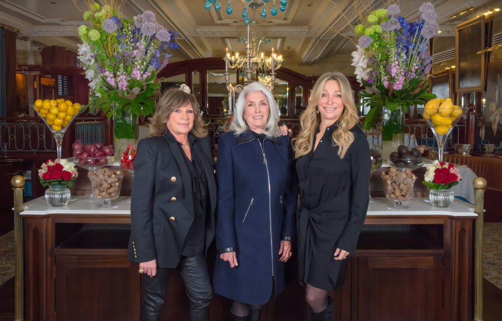 Three women standing in front of a bar on International Women's Day.