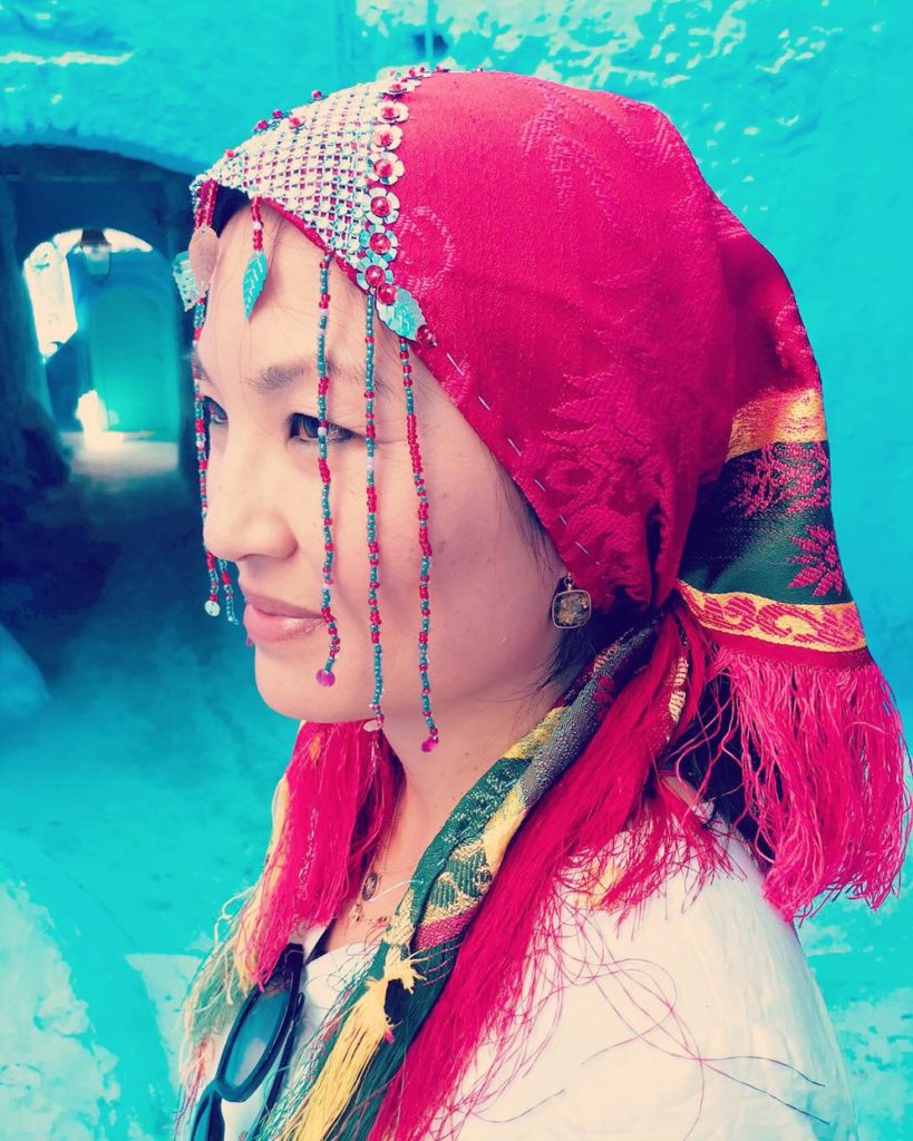 In honor of International Women's Day, a woman is seen wearing a red head scarf.