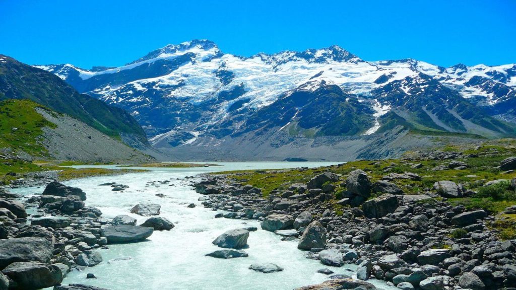 A river runs through a mountain in New Zealand, making it a must-see on your travel bucket list.
