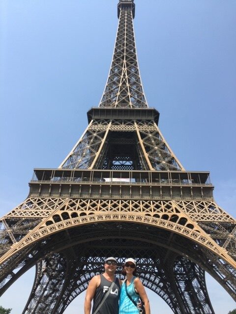 A cancer survivor standing in front of the Eiffel Tower.