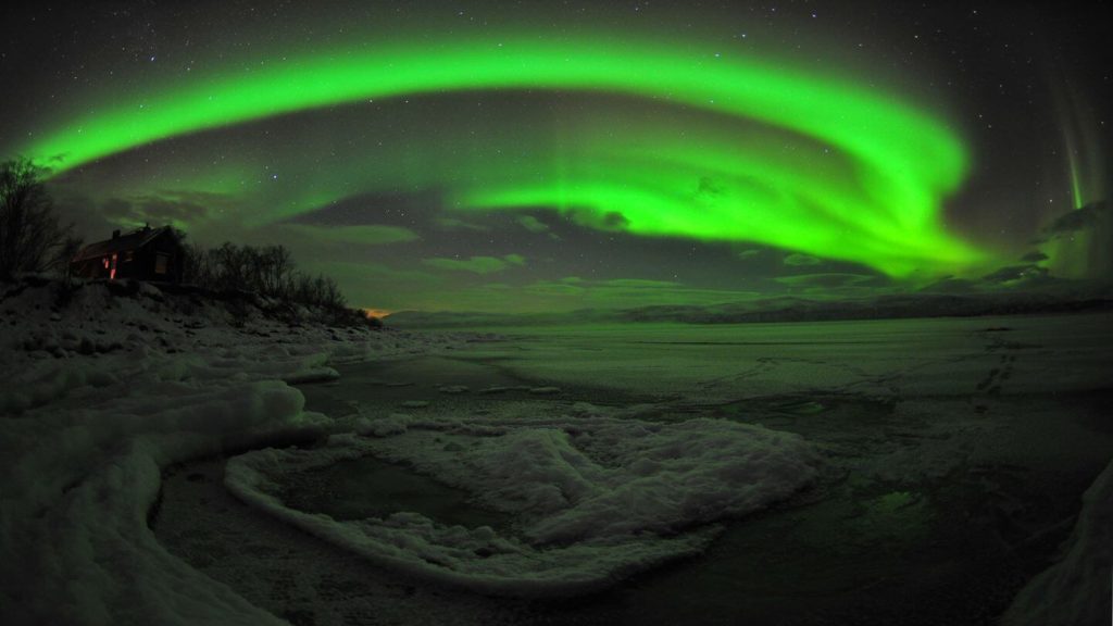 Experience the mystical beauty of a green aurora borealis illuminating a frozen lake. Perfect for a virtual field trip or virtual tour for kids.