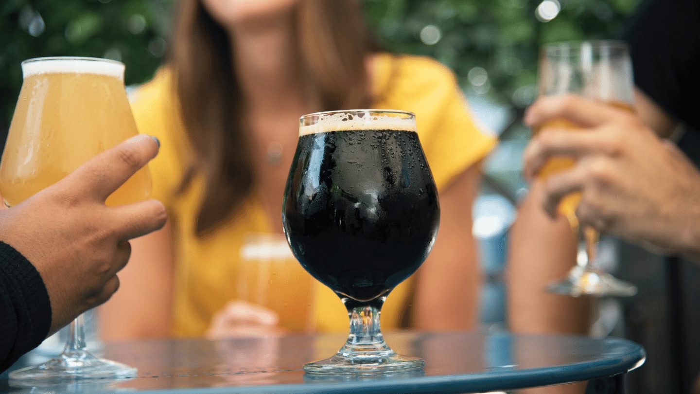 Pint of Guinness on table surrounded by people
