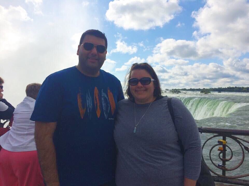 Two people touring with Trafalgar stand in front of Niagara Falls.