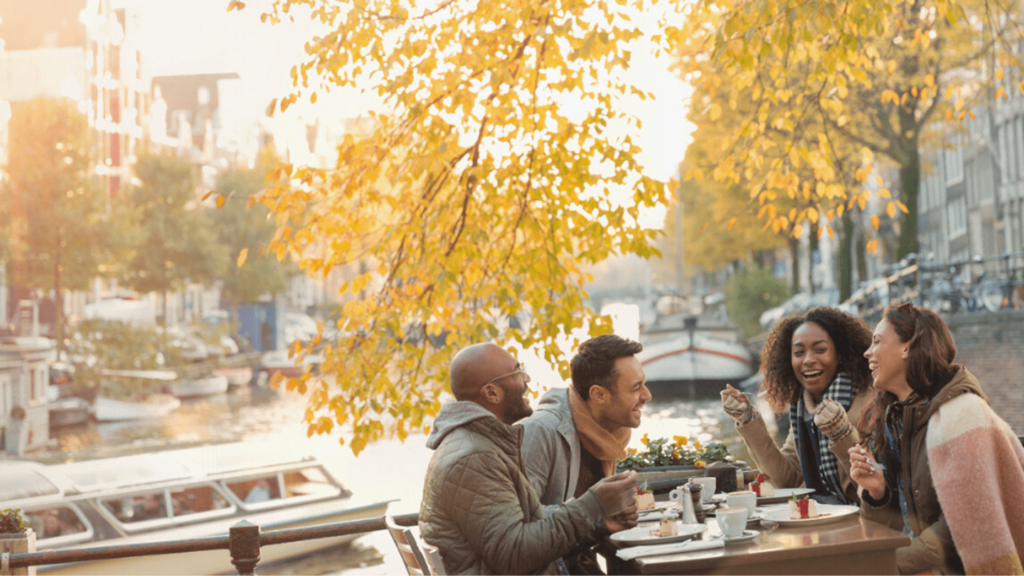 group of friends having lunch by a river