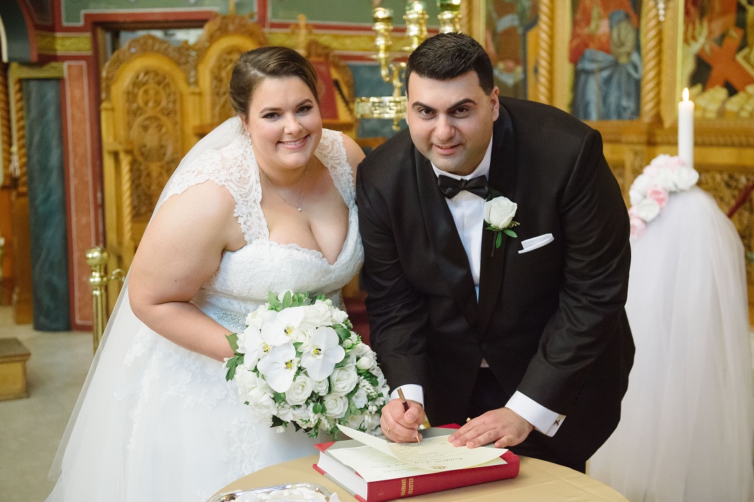 A bride and groom are signing their wedding vows at a church.