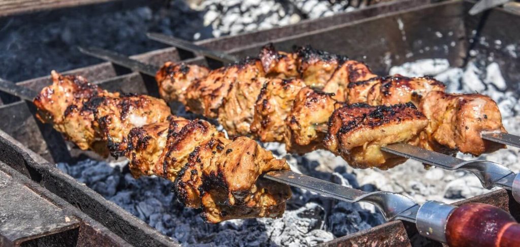 meat skewers grilling over hot coals