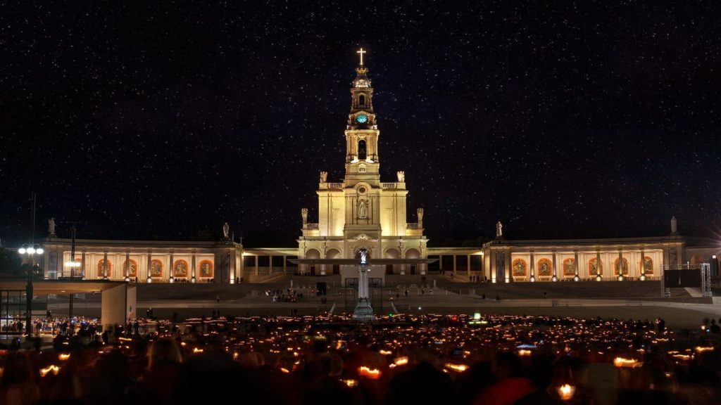 Sanctuary of Fatima worshippers holding candles at night Portugal