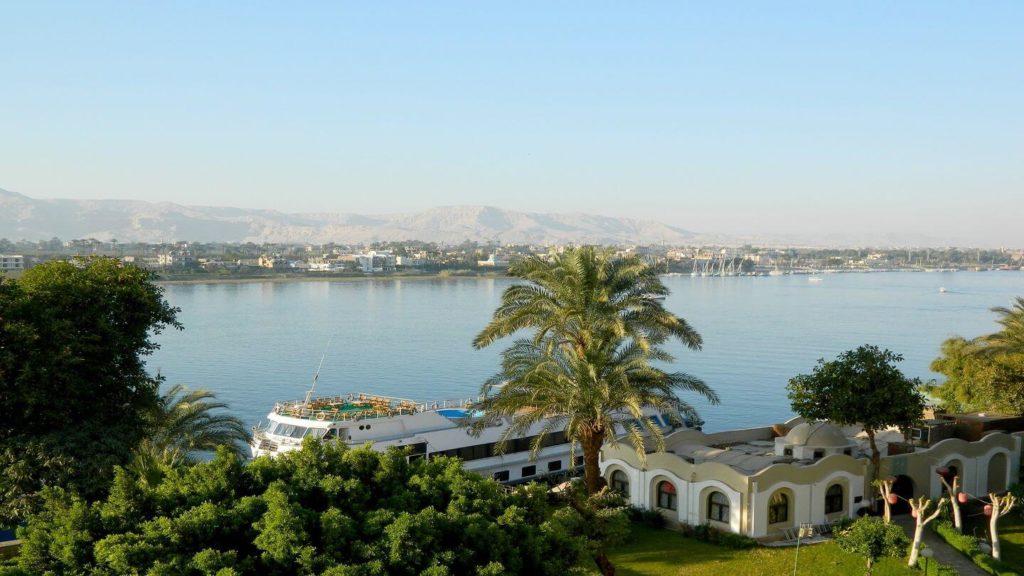 cruise boat and tropical trees on the Nile river Egypt