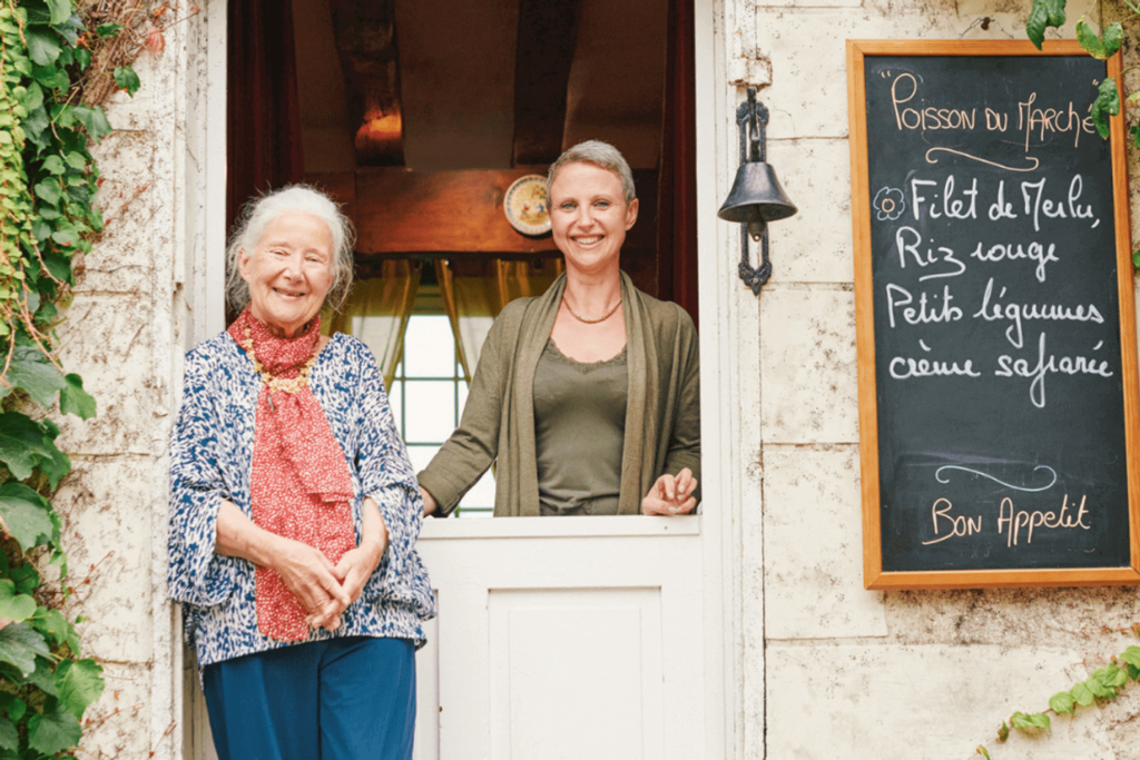 two women at their restaurant in France dining with strangers