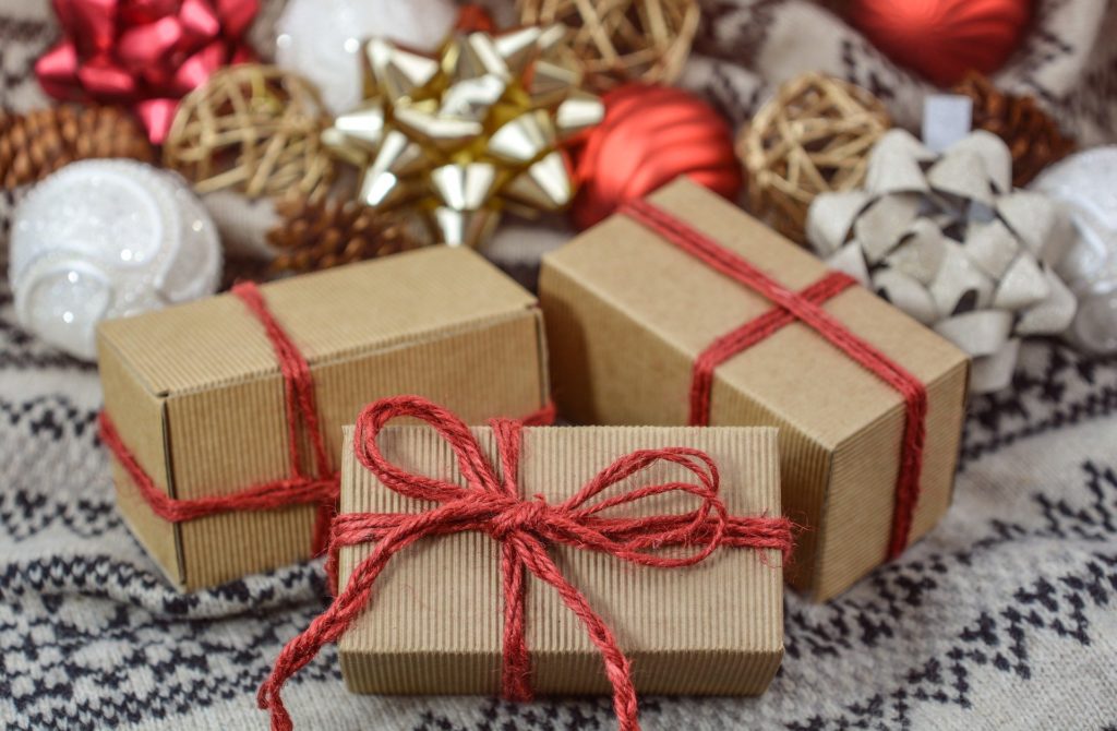 Kraft paper-wrapped gifts with red strings, among assorted Christmas decorations, evoking Argentinian Christmas traditions.