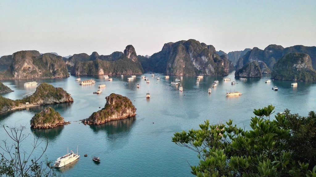 Scenic view of Ha Long Bay, a best of Asia travel destination, with tourist boats amid limestone islands.