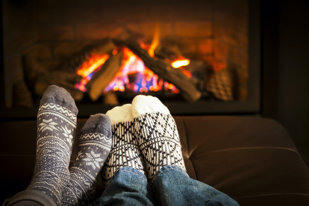 Decorative wool socks warming up by the fireplace.