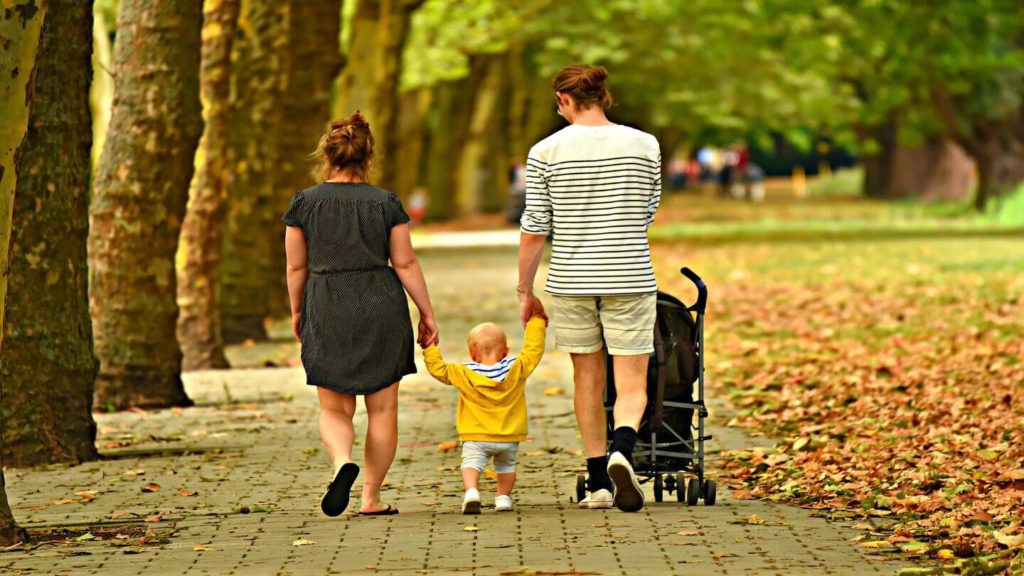 parents holding hands with their baby 