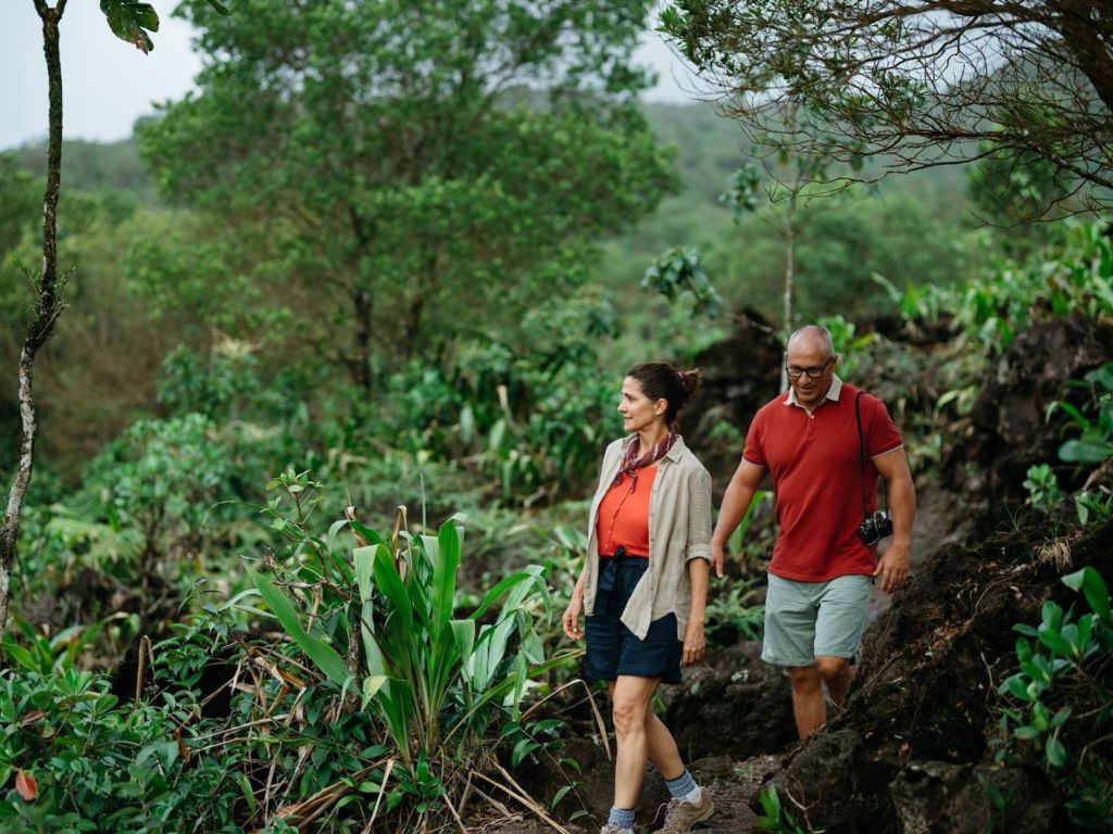 A couple hiking on a lush forest trail, experiencing ecotourism in Costa Rica.
