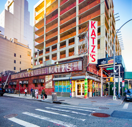 Katz's delicatessen, a famous American film location storefront at the corner of a city street with a construction site in the background.