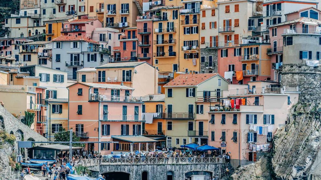 Colorful buildings stacked on a steep hillside in a picturesque coastal village, making it one of the must-visit places in Cinque Terre.