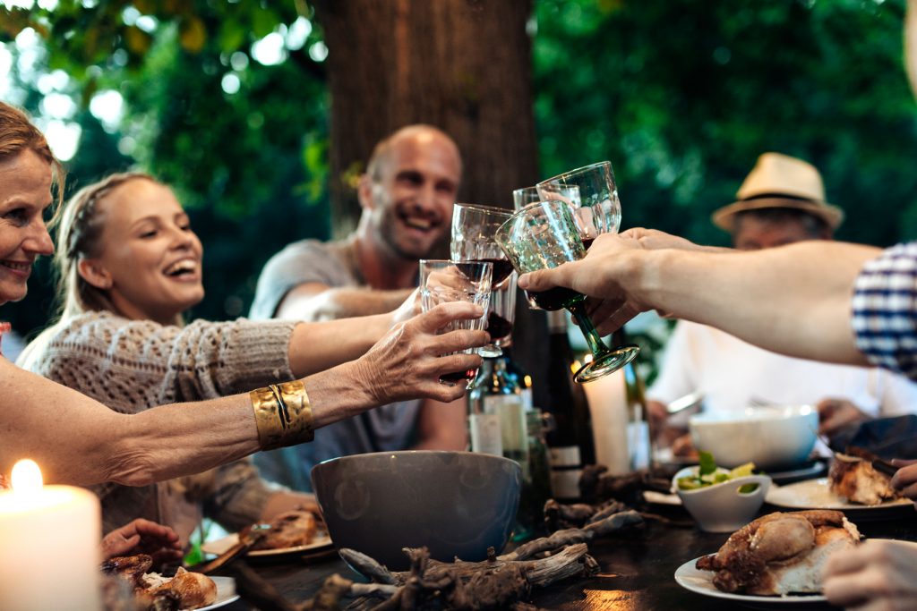 group of people clinking glasses over dinner