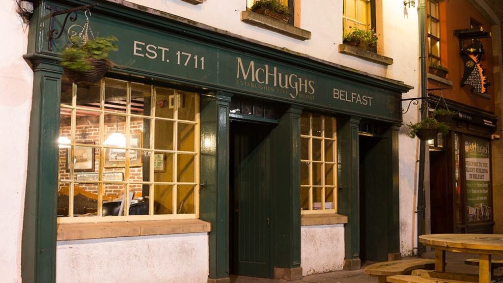Exterior of McHugh's, one of the oldest pubs in Britain, in Belfast, established in 1711, illuminated at night.